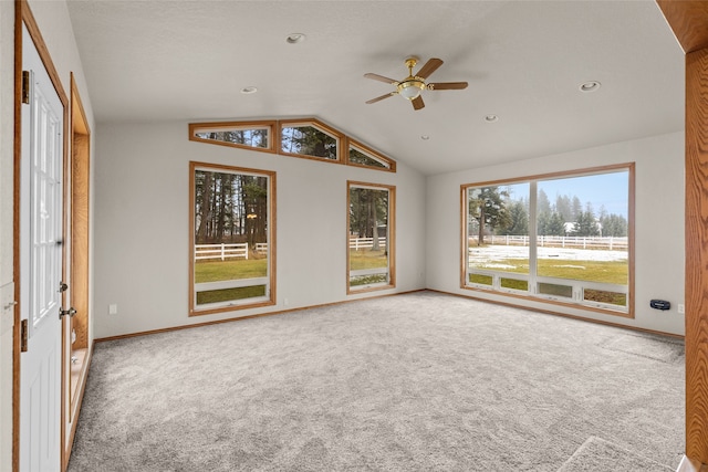 interior space featuring carpet, vaulted ceiling, and plenty of natural light