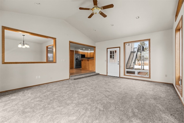 unfurnished living room with carpet, ceiling fan with notable chandelier, and vaulted ceiling