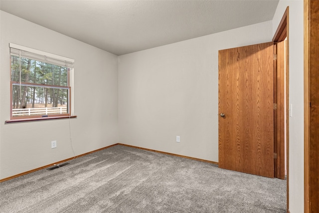 spare room with carpet and a textured ceiling