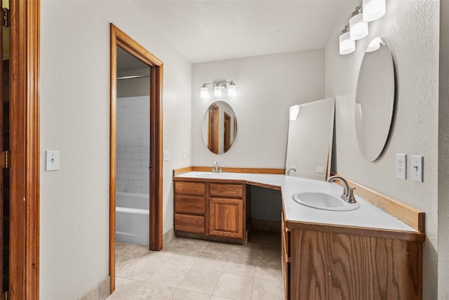 bathroom featuring tile patterned flooring, vanity, and tiled shower / bath