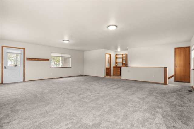 unfurnished living room with light colored carpet