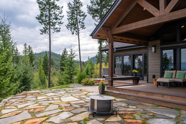 view of patio / terrace featuring a wooded view and a wooden deck