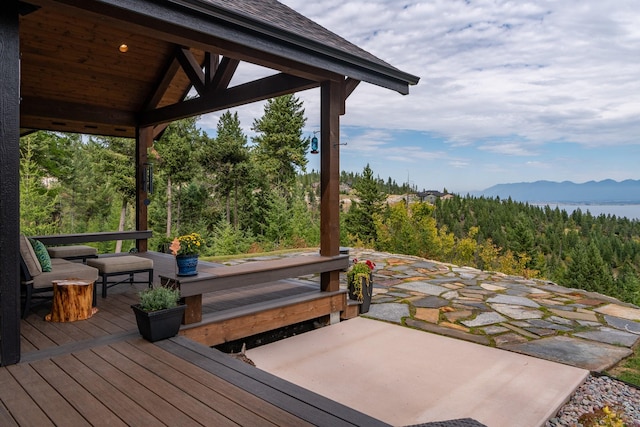 wooden deck with a mountain view and a wooded view