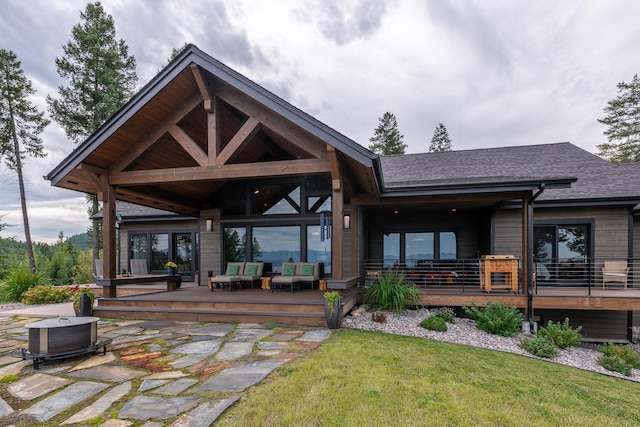 back of house with a lawn, a shingled roof, an outdoor living space, and a deck