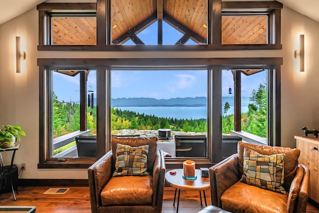 living area featuring a wealth of natural light, lofted ceiling, and wood finished floors