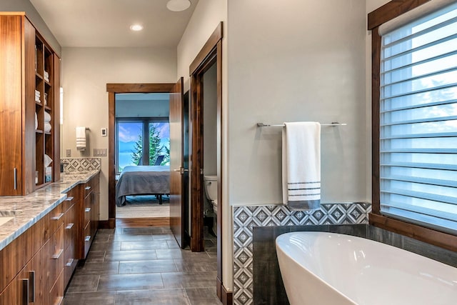 bathroom featuring vanity, toilet, recessed lighting, ensuite bathroom, and a soaking tub