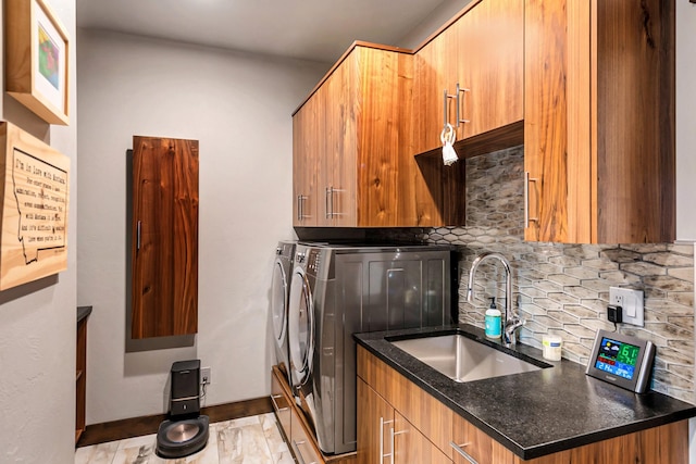 washroom featuring separate washer and dryer, a sink, and cabinet space