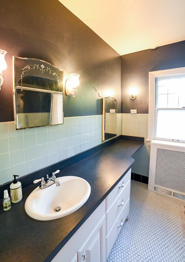 bathroom with vanity, tile walls, tile patterned flooring, and radiator heating unit