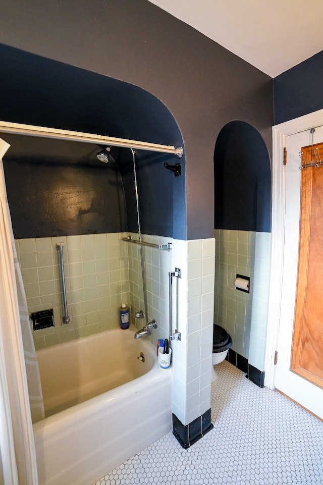 bathroom with tile patterned flooring,  shower combination, and toilet