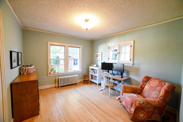 office area featuring radiator heating unit, a textured ceiling, light hardwood / wood-style flooring, and crown molding