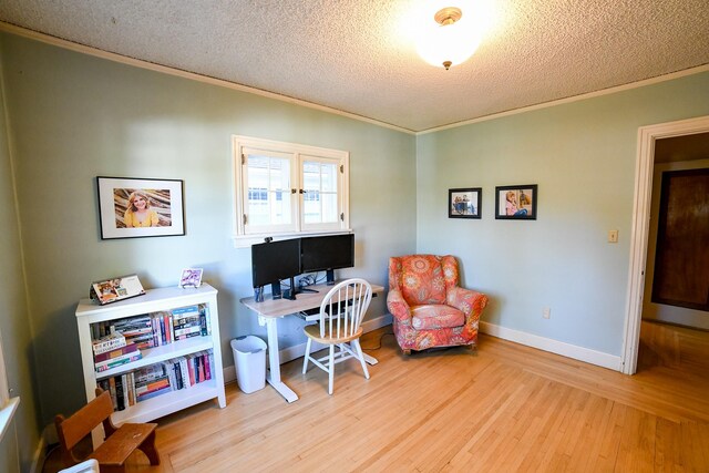 home office featuring light hardwood / wood-style floors, crown molding, and a textured ceiling