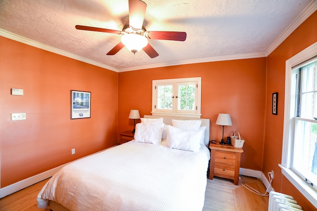 bedroom featuring ceiling fan, light wood-type flooring, and crown molding