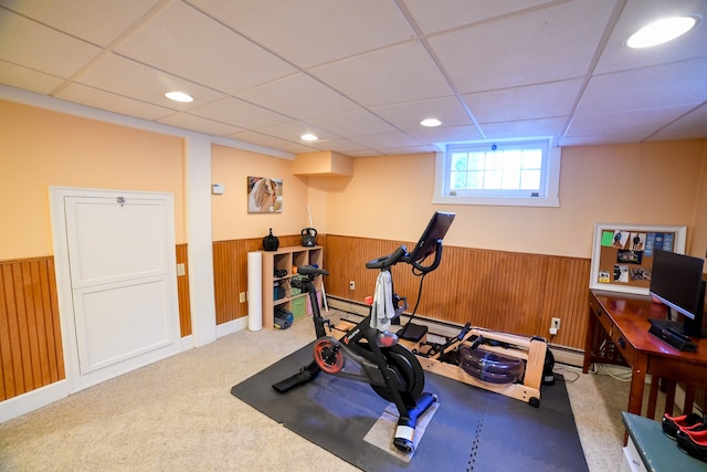 workout area with wooden walls, carpet floors, and a paneled ceiling