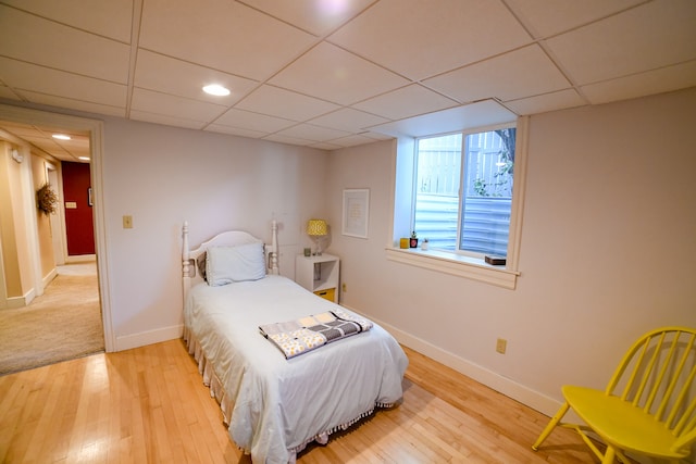 bedroom featuring hardwood / wood-style floors and a paneled ceiling