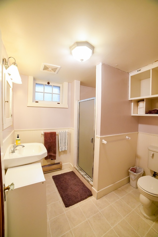 bathroom with vanity, baseboard heating, a shower with door, toilet, and tile patterned floors