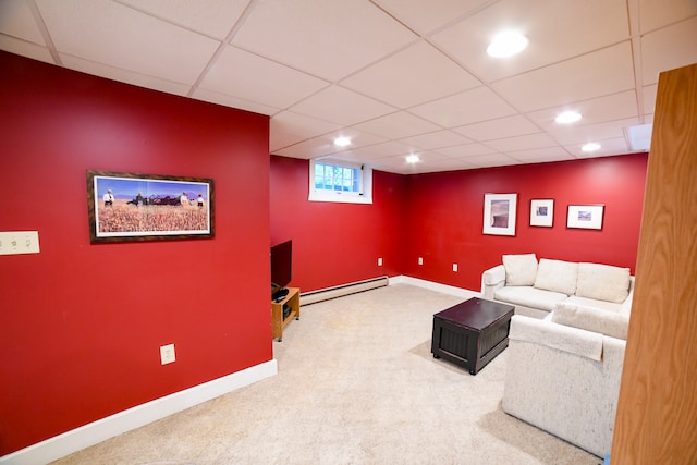 carpeted living room with a drop ceiling and a baseboard heating unit