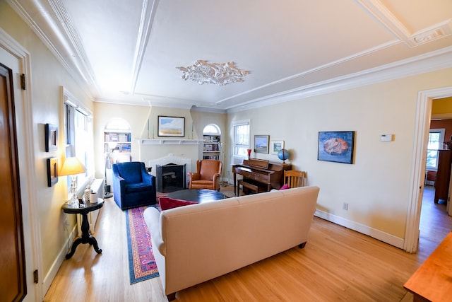 living room with light wood-type flooring, ornamental molding, and a wealth of natural light