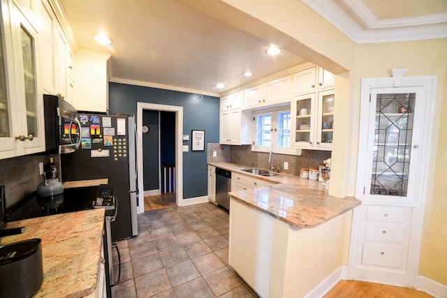 kitchen featuring light stone counters, stainless steel appliances, sink, and decorative backsplash