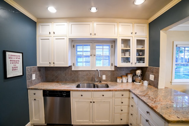 kitchen with decorative backsplash, stainless steel dishwasher, sink, and white cabinets