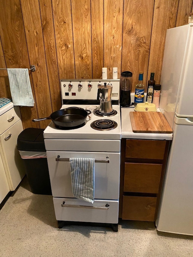 106 State St, Hamilton, MT 59840 - kitchen with white appliances, wood walls, light countertops, and brown cabinets