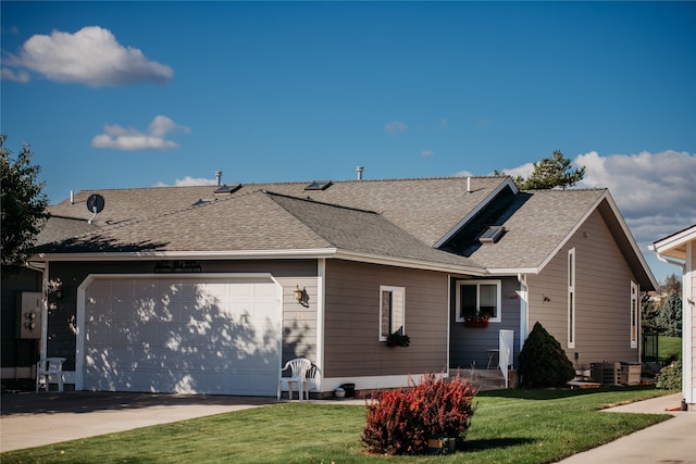 view of side of property with a yard, a garage, and central AC unit