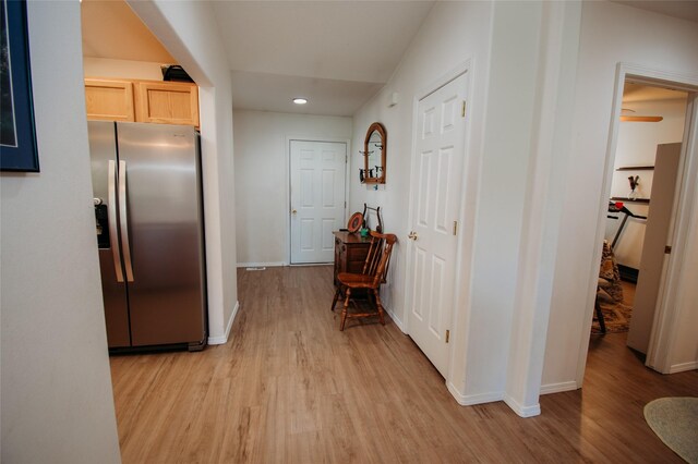 kitchen with stainless steel fridge, light brown cabinetry, and light hardwood / wood-style flooring