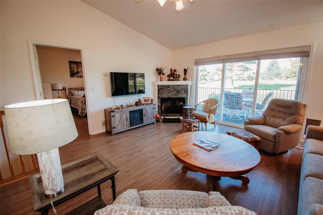 living room with lofted ceiling, hardwood / wood-style flooring, and a fireplace