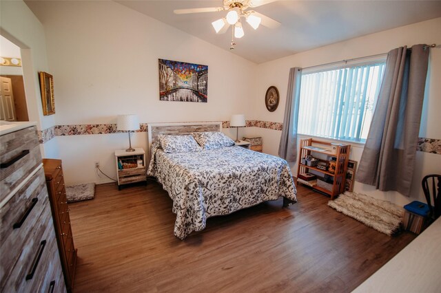 bedroom with vaulted ceiling, dark wood-type flooring, and ceiling fan