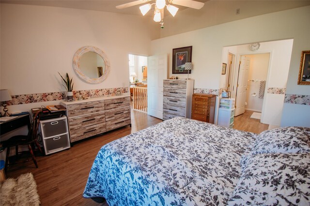 bedroom with ceiling fan, ensuite bath, dark hardwood / wood-style floors, and vaulted ceiling