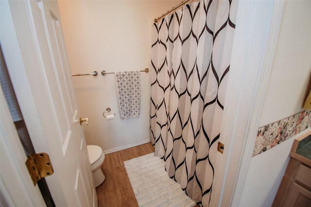 bathroom featuring wood-type flooring and toilet