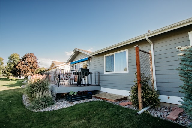 rear view of property featuring a wooden deck and a yard