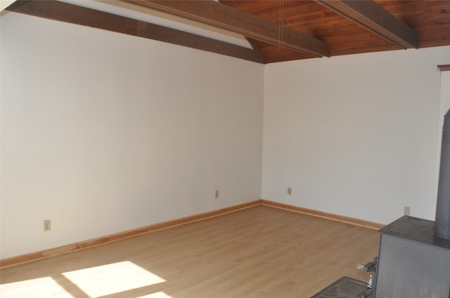 empty room featuring light hardwood / wood-style floors, beam ceiling, and wooden ceiling