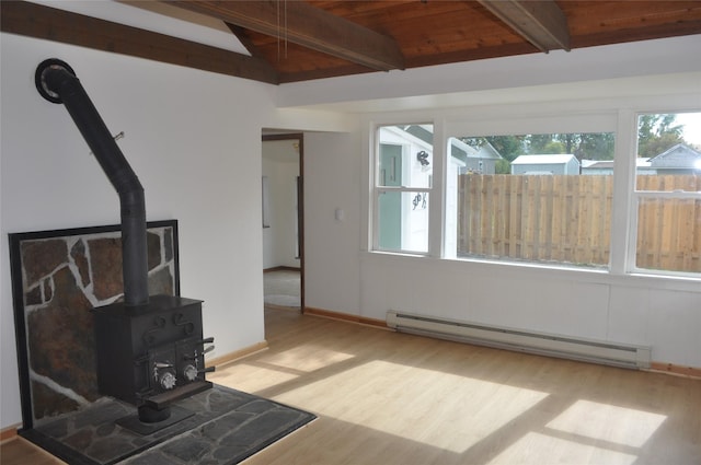 506/5061/2 W 3rd St, Polson, MT 59860 - unfurnished living room featuring a baseboard radiator, a wood stove, wood finished floors, and baseboards