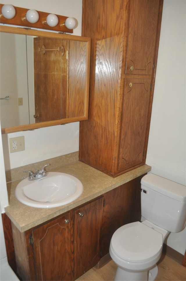 bathroom featuring wood-type flooring, vanity, and toilet