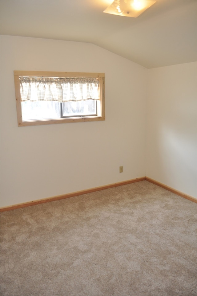 empty room featuring carpet floors and vaulted ceiling