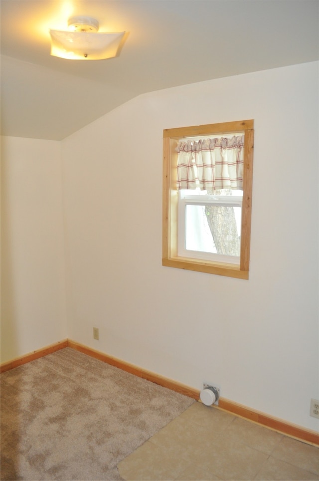 empty room with vaulted ceiling and carpet floors