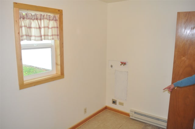 clothes washing area with a baseboard heating unit, hookup for an electric dryer, and light tile patterned flooring