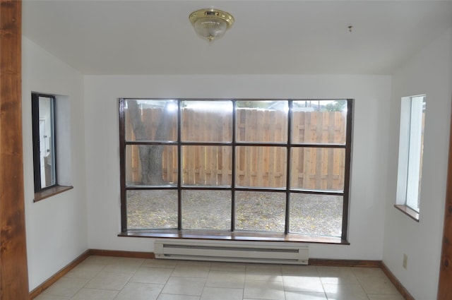 506/5061/2 W 3rd St, Polson, MT 59860 - spare room with baseboard heating, healthy amount of natural light, baseboards, light tile patterned flooring, and lofted ceiling