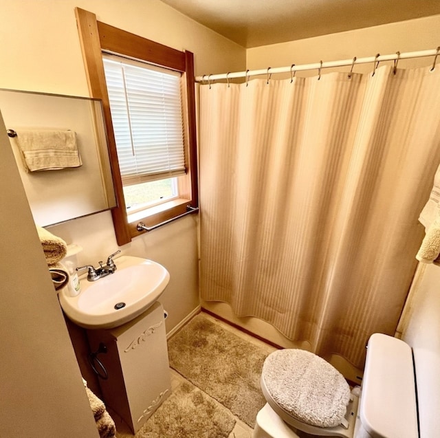 bathroom featuring walk in shower, vanity, toilet, and tile patterned floors