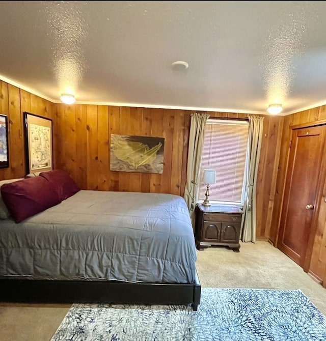 carpeted bedroom featuring a textured ceiling and wood walls