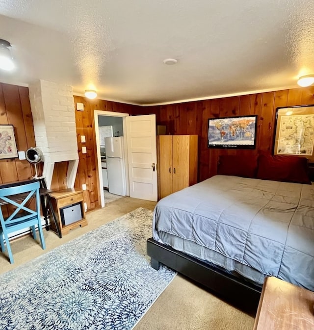 bedroom featuring light carpet, a textured ceiling, and white fridge