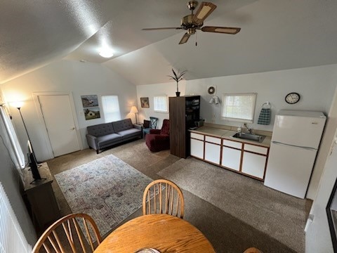 interior space featuring a wealth of natural light, lofted ceiling, ceiling fan, and white refrigerator