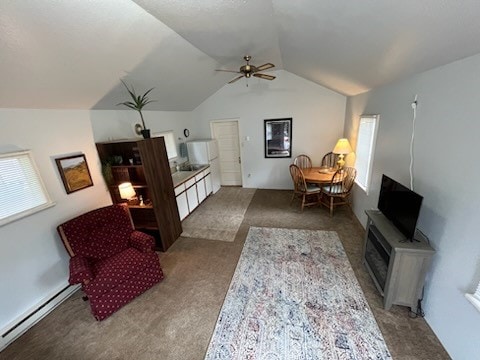 living area with carpet flooring, vaulted ceiling, baseboard heating, and ceiling fan