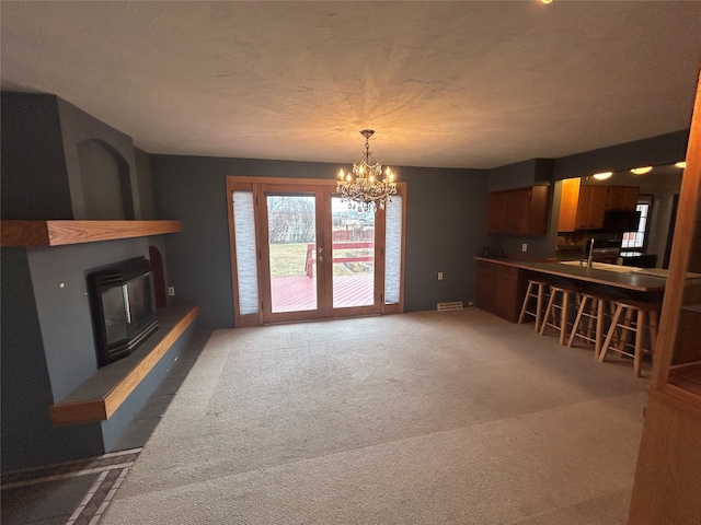 living room featuring a notable chandelier, dark carpet, and a textured ceiling