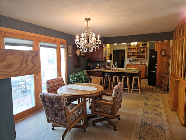 carpeted dining space featuring a chandelier and a textured ceiling