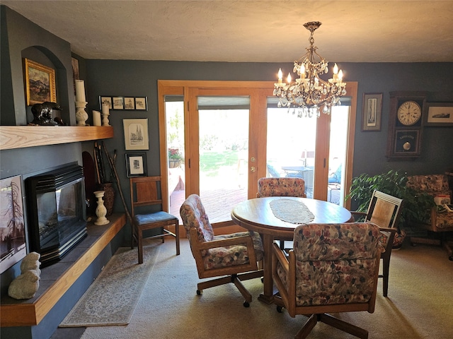 dining area featuring carpet, a textured ceiling, and a chandelier