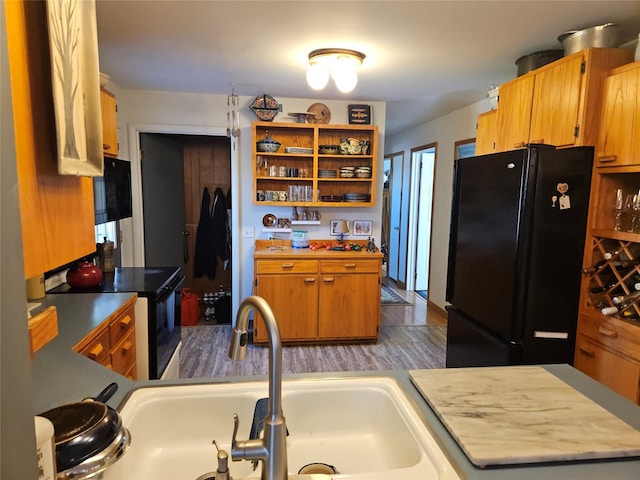 214 Laura St, Augusta, MT 59410 - kitchen featuring black appliances, open shelves, wood finished floors, and brown cabinetry