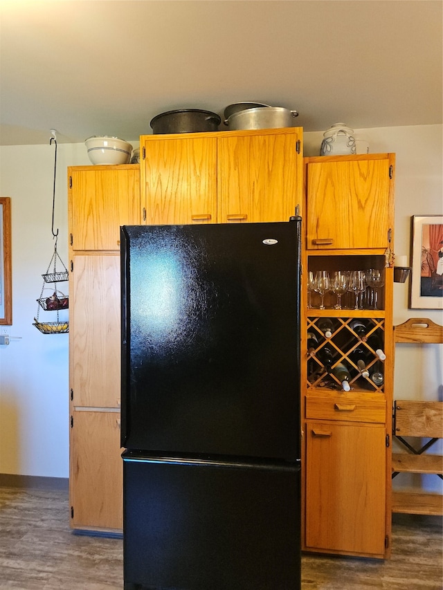 kitchen featuring dark hardwood / wood-style flooring and black fridge