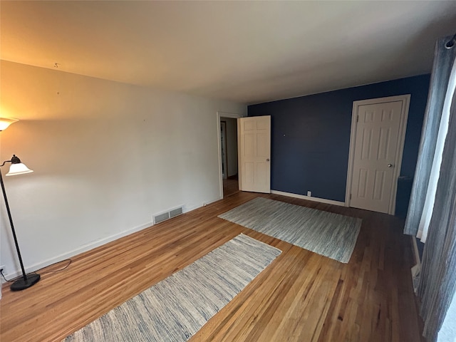 unfurnished room with hardwood / wood-style flooring