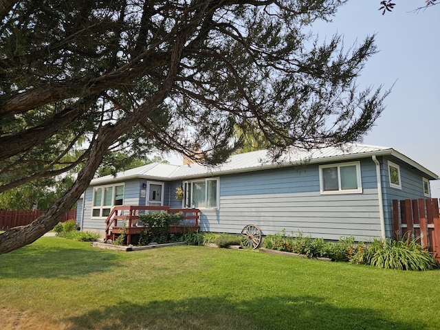 rear view of house with a yard and a wooden deck